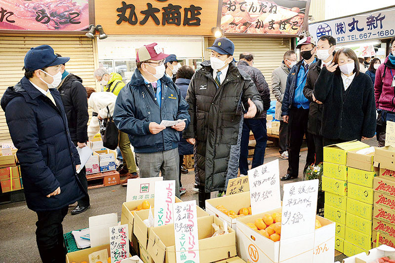 市場関係者の話を聞きながら場内を視察する清水勇人市長＝28日午前、さいたま市北区吉野町の大宮市場