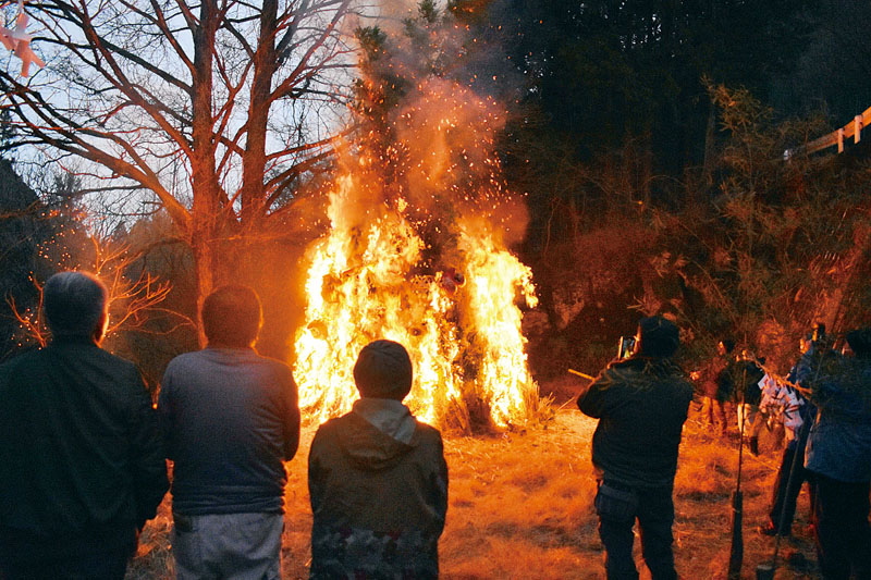 正月飾りで作った小屋を燃やし、火難よけを祈願する橋詰地区の住民ら＝21日午後5時ごろ、小鹿野町河原沢