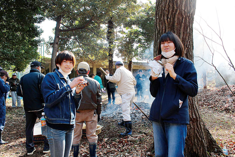 焼き芋会でホクホクの芋をほおばる参加者たち