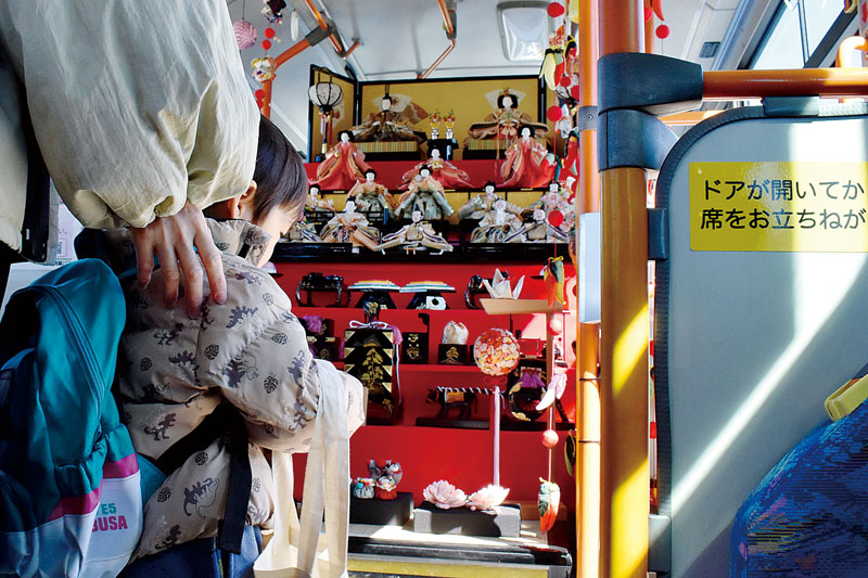 バス車内に展示されたひな人形飾りを楽しむ参加者＝飯能市