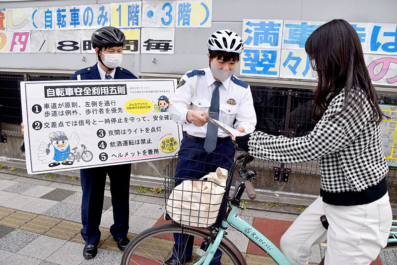 キャンペーンでヘルメットの着用を呼びかける警察官（中央）＝3月31日午後、埼玉県さいたま市浦和区