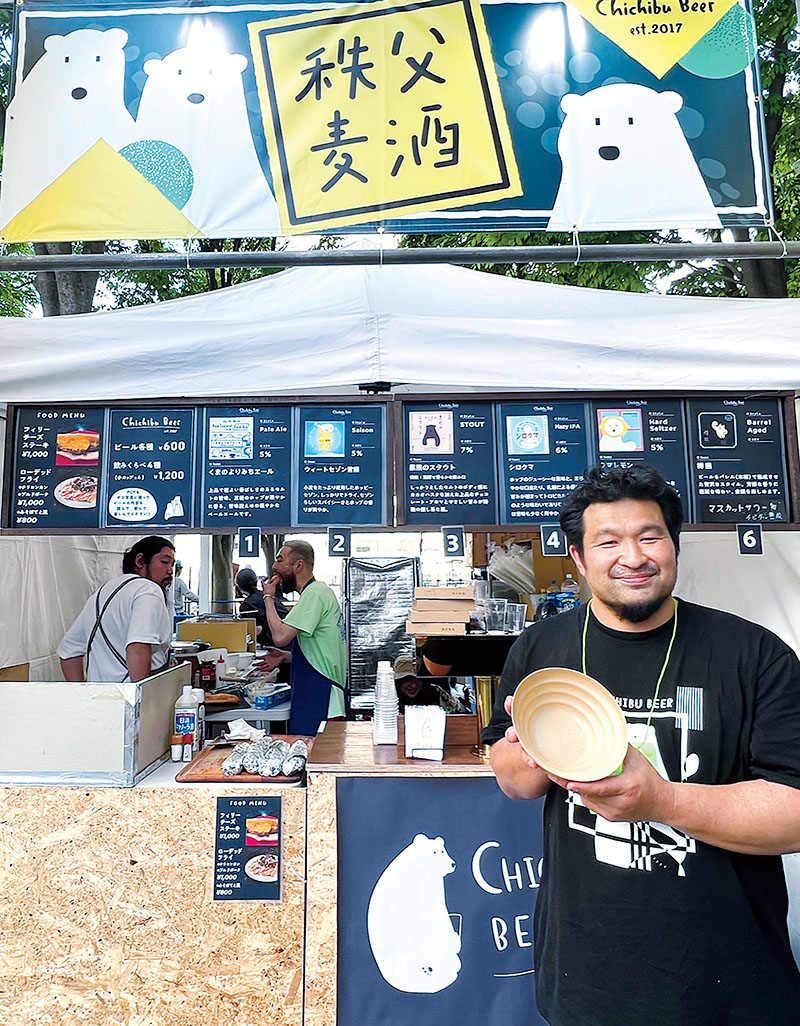 プラスチックごみ削減のため、採用した循環器型食器を手にする秩父麦酒醸造所代表の丹広大さん＝17日午後、さいたま市中央区