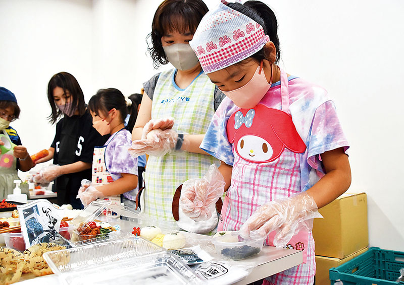 おむすび作り体験ブースでお弁当を作る子どもたち