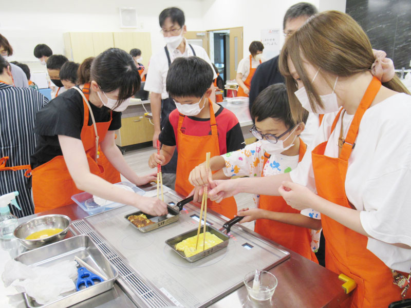 厚焼き玉子に挑戦する親子＝26日昼、深谷市の三菱電機ホーム機器クッキングスタジオ