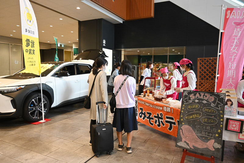 みそポテトの販売コーナーで、給電を実演する電気自動車「bZ4X」（左）＝8日、埼玉県さいたま市大宮区の大宮門街