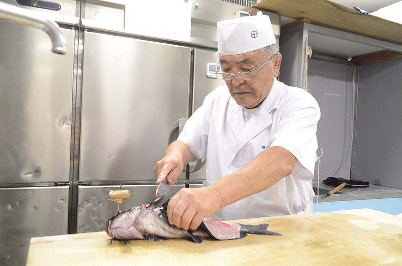 ナマズをさばく小林政夫会長＝埼玉県吉川市