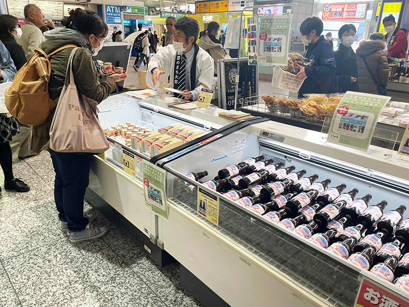 「鉄道のまち大宮」のロゴが入ったビールやケーキが並ぶ県産品フェア＝13日、埼玉県さいたま市大宮区のJR大宮駅イベントスペース