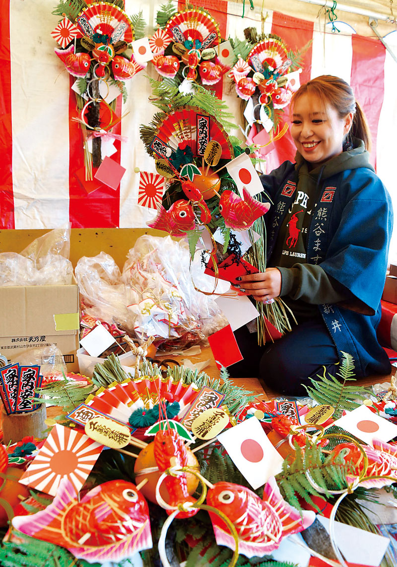 組み立てられる華やかな正月飾り＝25日午後、埼玉県熊谷市の市役所通りのお祭り広場