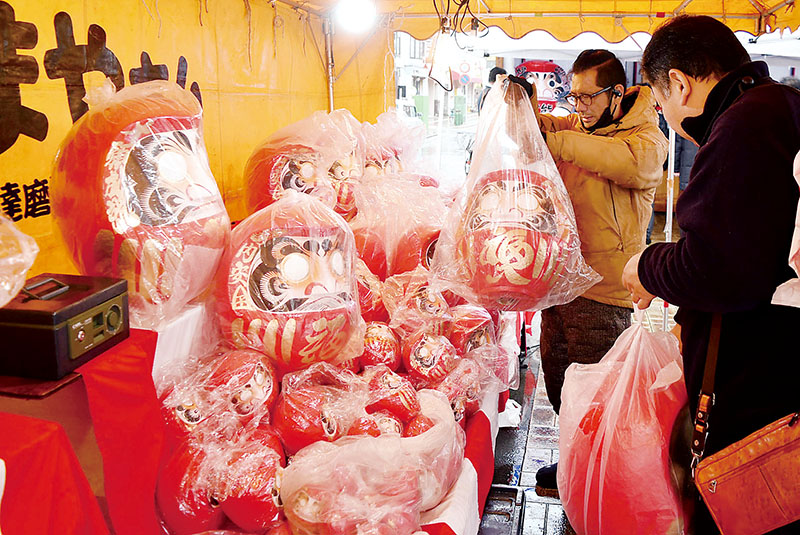 来場者がだるまを買い求めただるま市＝21日午前、埼玉県熊谷市星川の星川通り