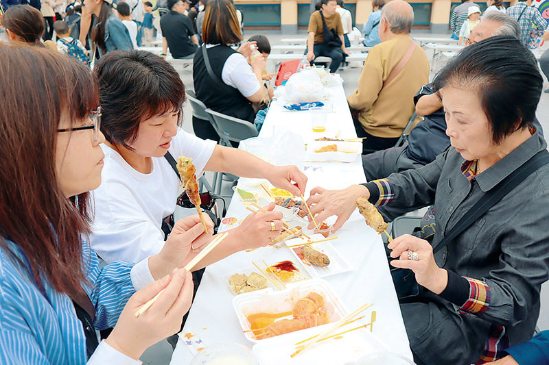 各店舗のさまざまな「串ぎょうざ」を楽しむ人たち＝丸広百貨店上尾店屋上