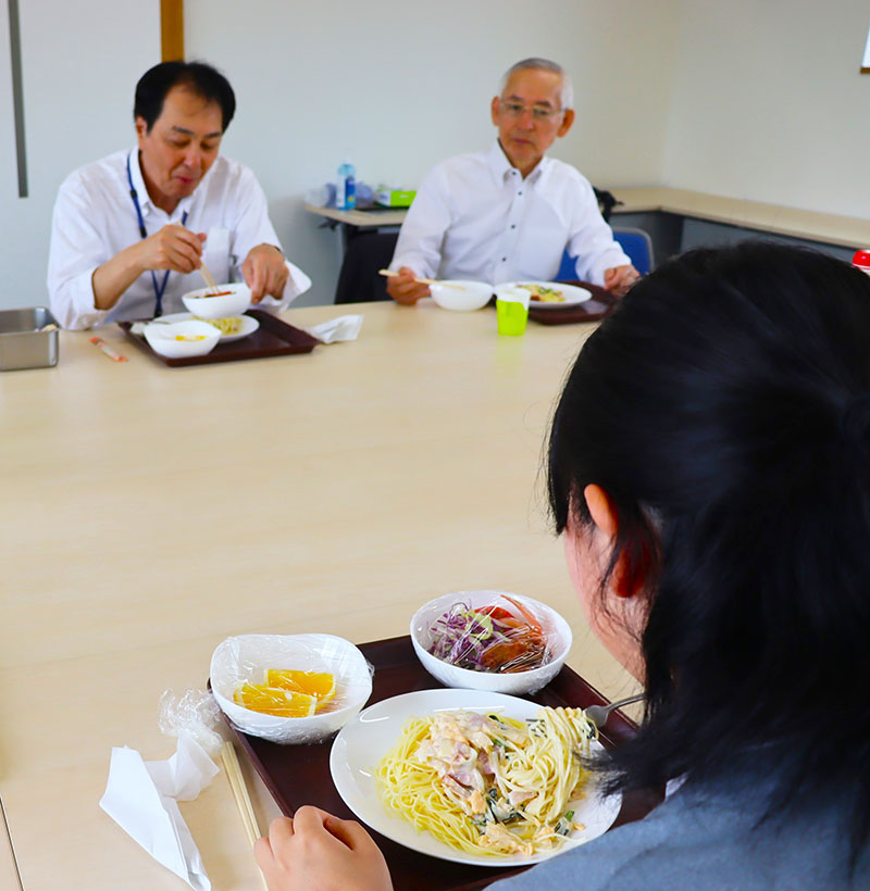 食事をしながら近況を話す卒園生（手前）＝4月29日、埼玉県春日部市の「子供の町」