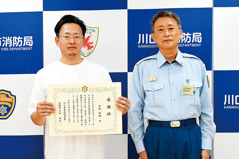 消防協力者表彰を受けた足利佳祐さん（左）と太田泰彰東消防署長＝5月29日午前、川口市坂下町の川口市消防局東消防署