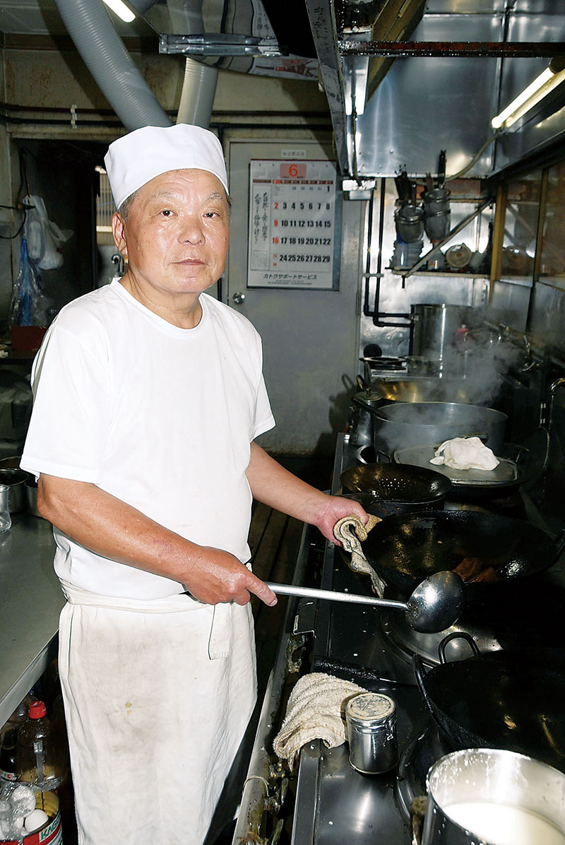 鍋を振るうマスターの市川政雄さん＝行田市本丸の「香港飯店」