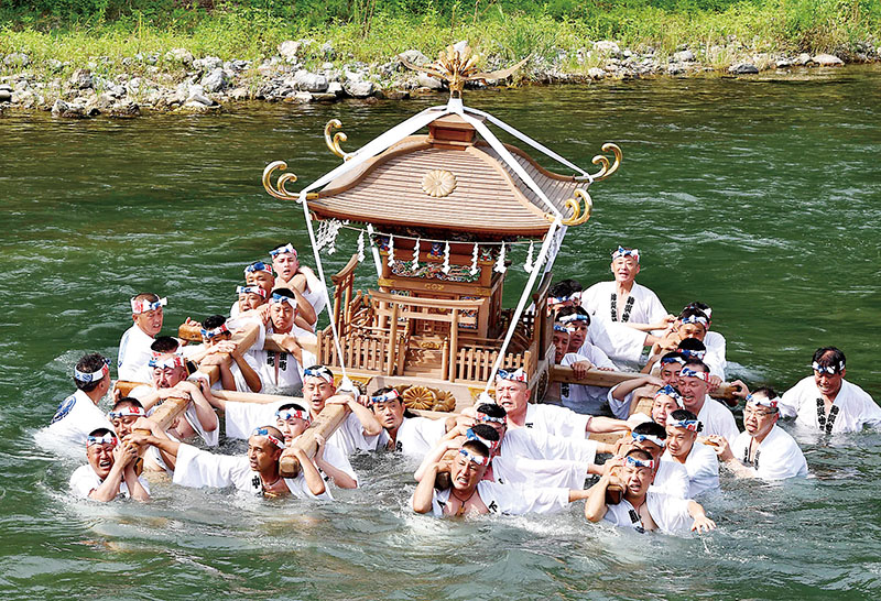 神輿を担いで川を練り歩く若者たち＝20日午後3時10分ごろ、秩父市の荒川