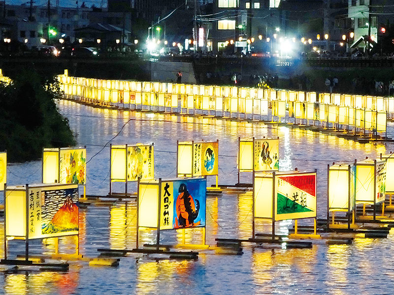 川面に浮かぶ流灯＝3日夜、杉戸町の古利根川河畔