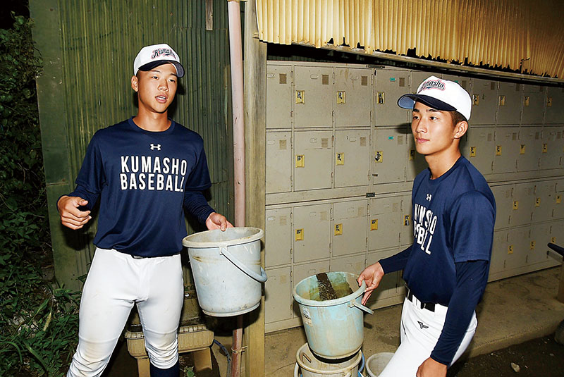 グラウンドでバケツリレーの消火活動を振り返る中村さん（左）と福嶋さん