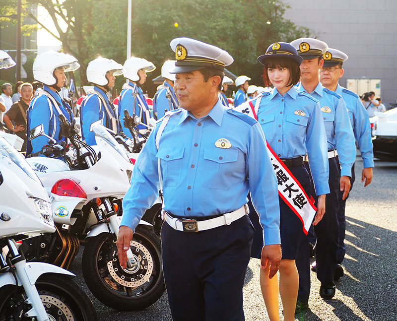 式典に参加した警察官らを巡閲する（左から）県警の荻野長武交通部長、小西桜子さんら＝20日午後、さいたま市浦和区の県庁