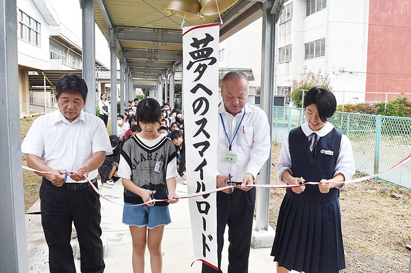 男衾小学校と男衾中学校の連絡通路のテープカットを行う代表者たち＝寄居町富田