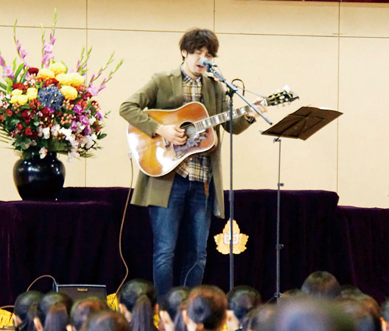 在校生を前に歌う小林さん（本人提供）