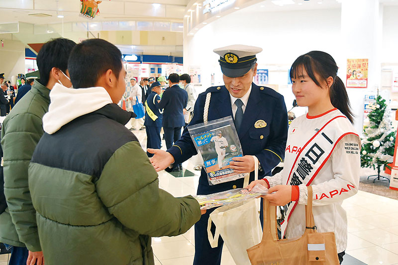 一日警察署長として啓発品を配布する沢田茉奈さん（右）＝4日午後、上里町金久保のイオンタウン上里ふれあいコート