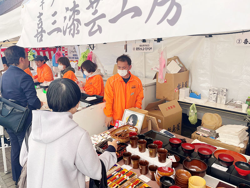 「喜三漆芸工房」で接客する喜三鷹也さん（奥右）＝6日午前、さいたま市南区