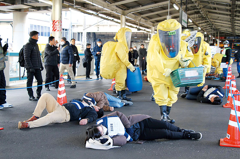 訓練では、化学剤で倒れた客を消防隊員が救出した