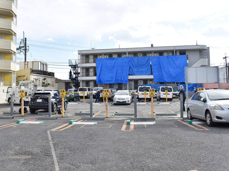 事件が起きたマンションと男性の黒い車（左）＝27日午後、所沢市東住吉