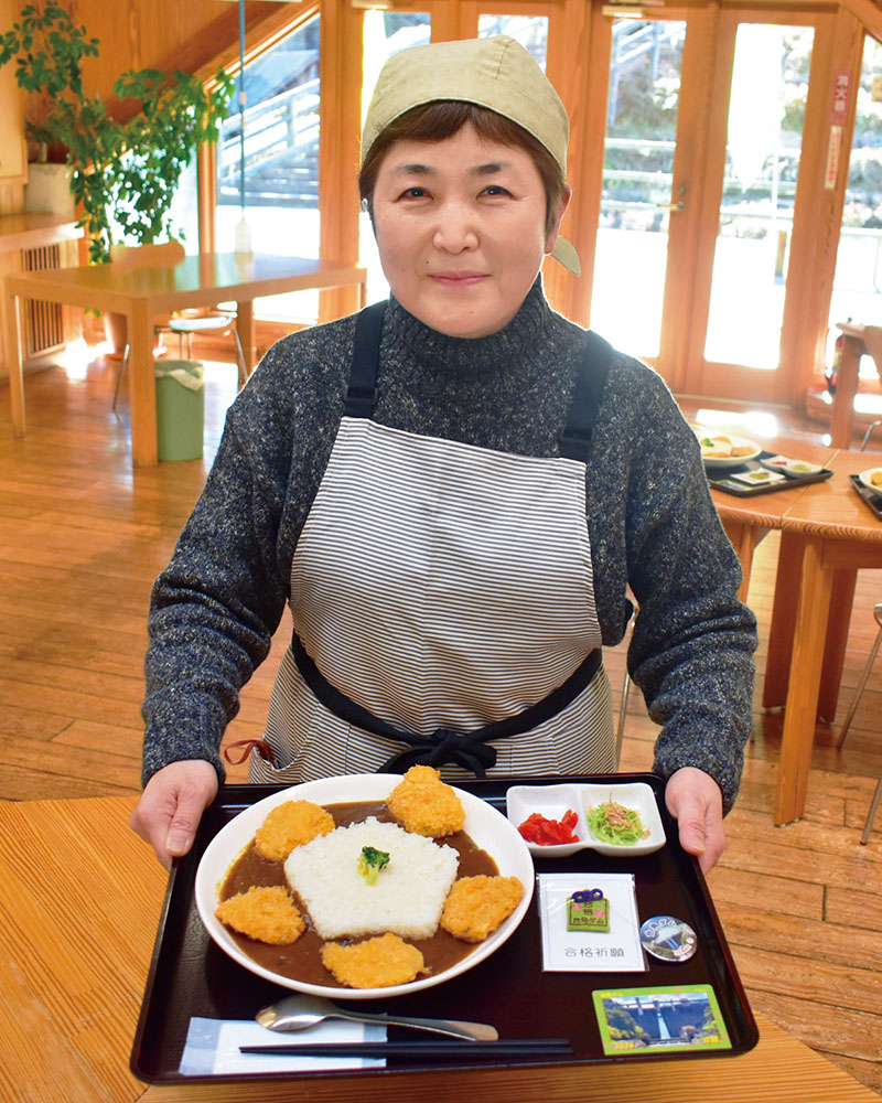 17日から限定販売する「ごうかくダムカレー」を紹介する、吉田元気村の今井里美所長