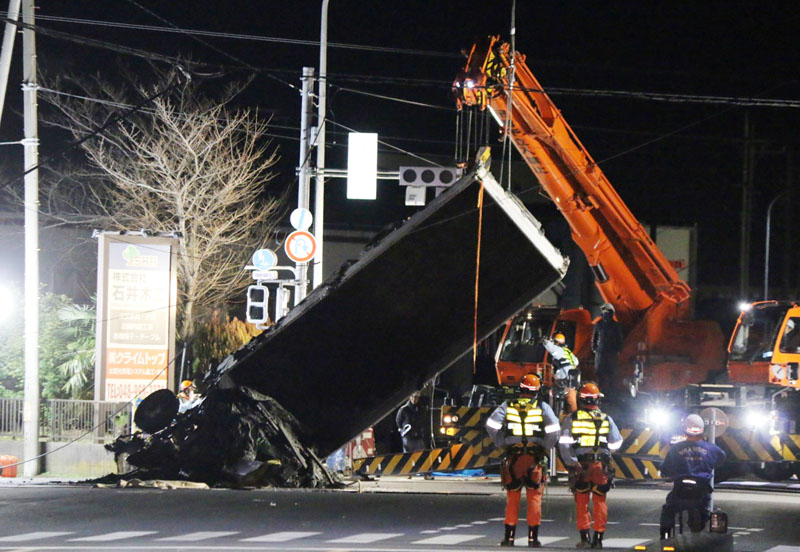 クレーン車で吊り上げられたトラックの一部＝29日午前2時35分ごろ、八潮市二丁目