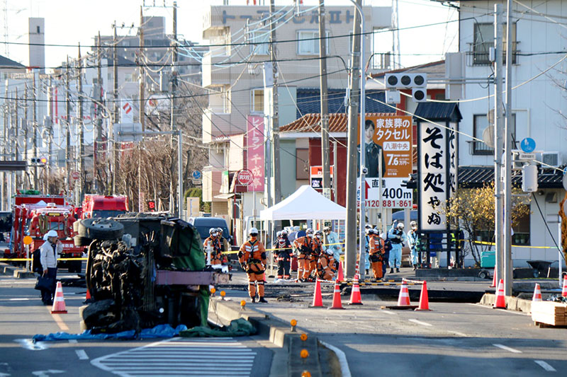 消防による救出作業が続く道路陥没現場。トラックの荷台部分が残っていた＝30日午後3時45分ごろ、八潮市二丁目