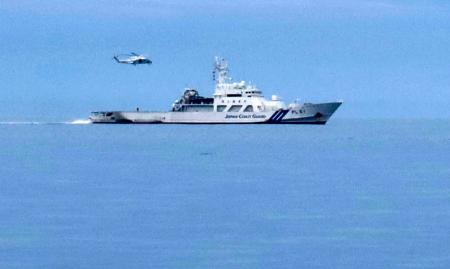 　沈没事故の現場海域で行われた訓練の様子。巡視船の上空をヘリコプターがホバリングしている＝２０日午前、北海道・知床半島沖