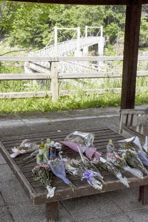 北海道留萌市の女子高生の殺害現場となった、旭川市の神居古潭地区にあるつり橋付近に手向けられた花束＝１５日