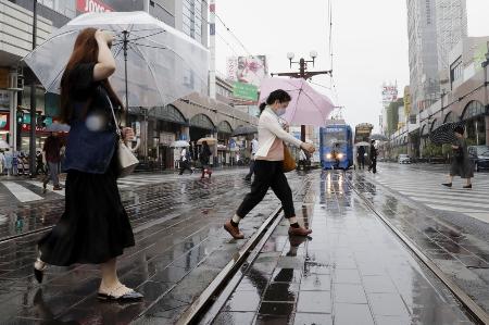 雨が降る鹿児島市内で、傘を差して歩く人たち＝２０日