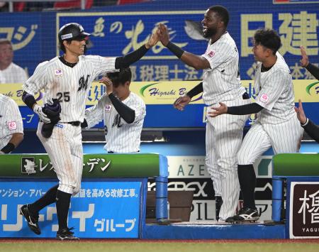 　７回、プロ野球新記録の８試合連続二塁打となった２点二塁打を放ち、選手交代でベンチに戻り、ナインとタッチを交わすロッテ・岡（左）＝ＺＯＺＯマリン