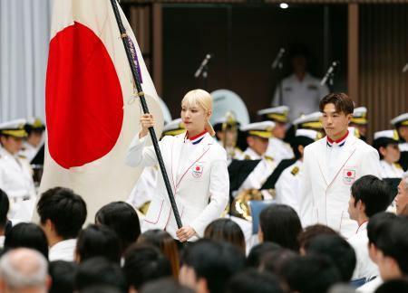 　パリ五輪日本選手団の結団式で、団旗を受け取った旗手の江村美咲（左）と半井重幸＝５日午後、東京・代々木第二体育館