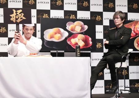 　ＧＡＣＫＴ（右）と「極」の札を上げる日本料理店主人＝東京都中央区