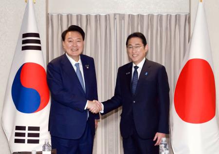 １０日、ワシントンで韓国の尹錫悦大統領（左）と握手する岸田首相（聯合＝共同）