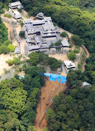 土砂崩れが発生した松山城付近の斜面＝１２日午前１０時３１分、松山市（共同通信社ヘリから）