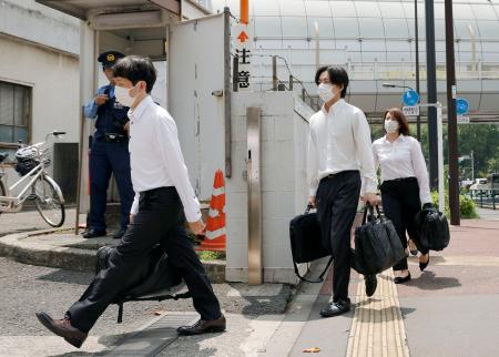 　自民党の堀井学衆院議員の議員宿舎へ家宅捜索に向かう東京地検特捜部の係官ら＝１８日午前１０時５３分、東京都港区