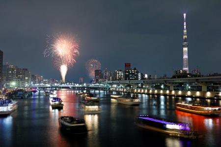 　東京・隅田川花火大会で打ち上げられた花火。右は東京スカイツリー＝２７日夜（多重露光）