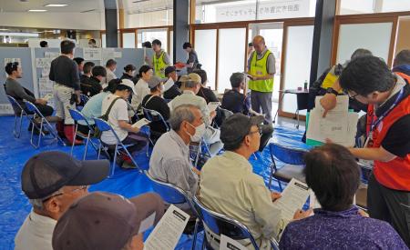 　活動開始前に注意事項など説明を受けるボランティア＝３０日午前、山形県酒田市