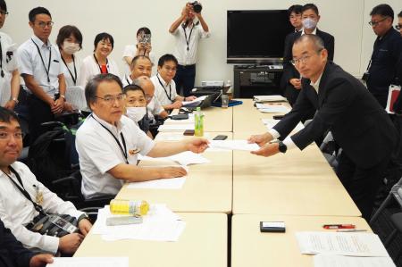 総務省の担当者（右）に要望書を提出する「障害者の自立と政治参加をすすめるネットワーク」の村上博熊本市議＝３０日午後、東京都千代田区