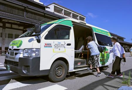 　石川県輪島市で運行が始まったオンデマンドバス「のらんけ＋（プラス）」に乗り込む住人たち＝１日午前