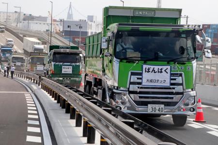 　開通した高架橋を通り、万博会場に入る工事車両＝１日午前、大阪市