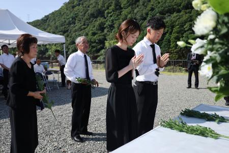 兵庫県佐用町で２０人が亡くなった豪雨災害から１５年となり、犠牲者の名前が刻まれたモニュメントの前で手を合わせる遺族ら＝９日午前