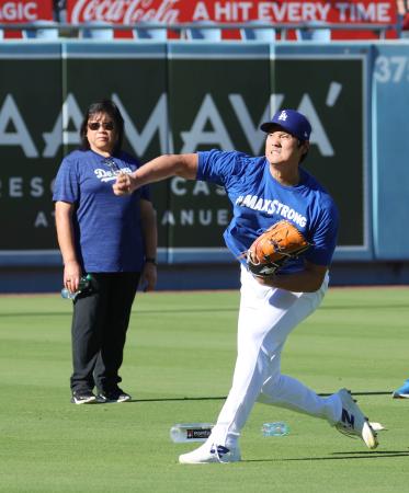 ２日続けてキャッチボールを行うドジャース・大谷。左は理学療法士のジュディ・セトさん＝ロサンゼルス（共同）