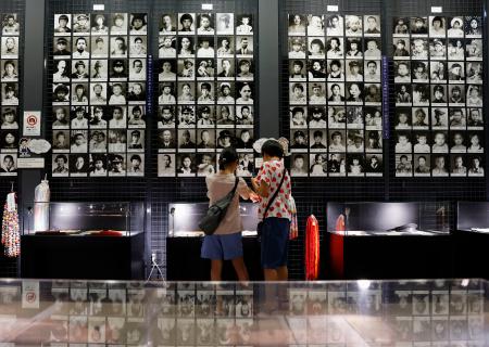 学童疎開船「対馬丸」の撃沈から８０年となり、学童らの遺影が掲示された対馬丸記念館を訪れた子どもたち＝２２日午前、那覇市