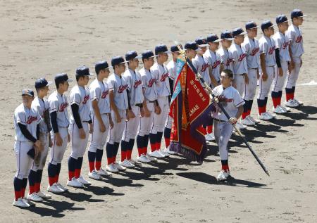 　閉会式で優勝旗を持つ京都国際の藤本主将＝２３日、甲子園球場