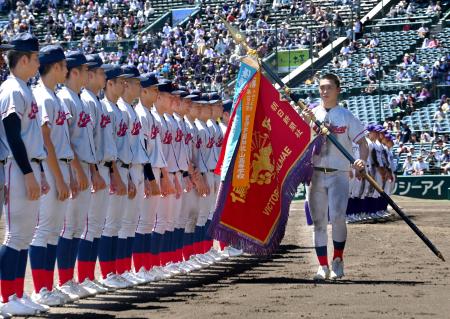 優勝旗を手にする京都国際の藤本主将＝２３日、甲子園球場（代表撮影）