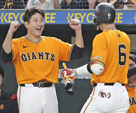 ７回、決勝２ランを放った坂本（６）を笑顔で迎える巨人・菅野＝東京ドーム